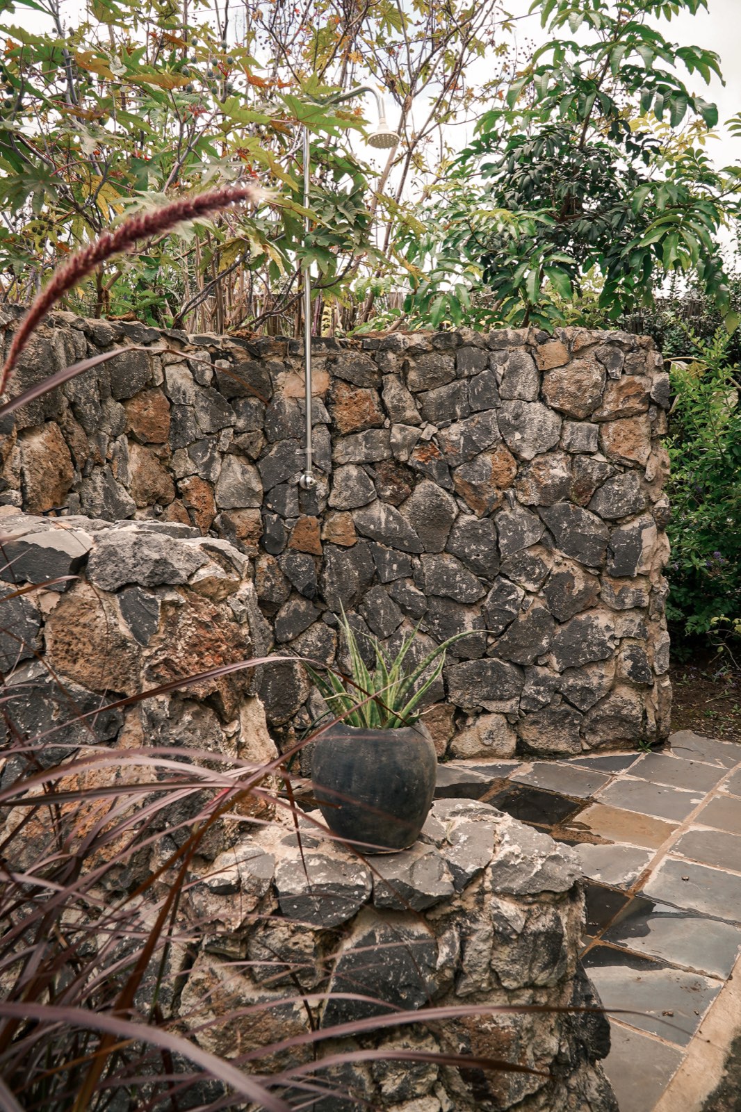Outdoor shower against a volcanic stone wall